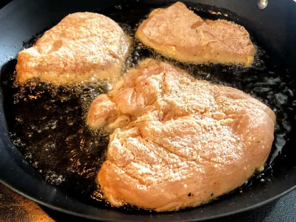 breaded chicken breasts in pan
