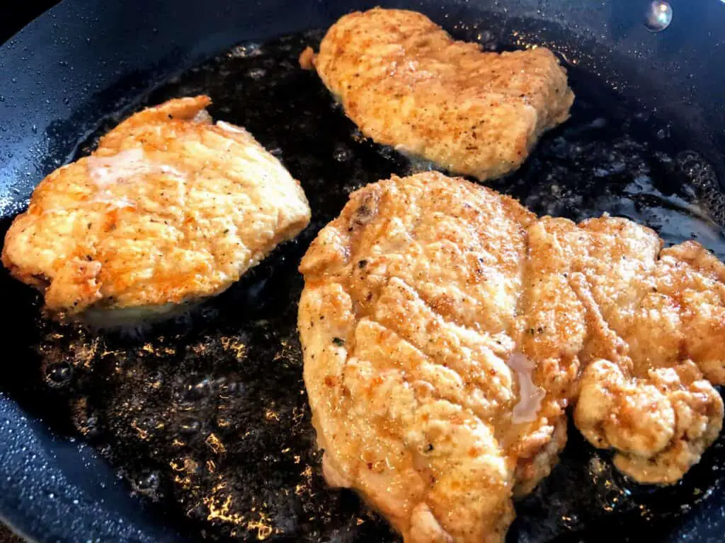 fried chicken breasts in pan