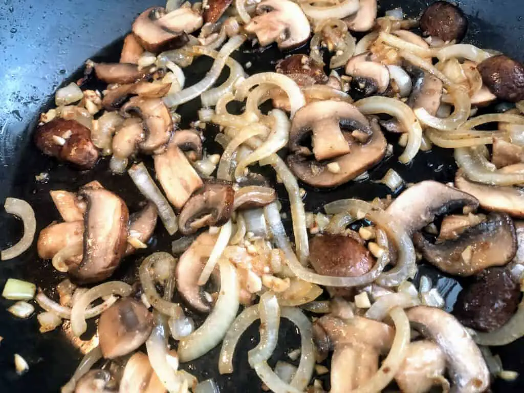chopped onions and mushrooms and garlic in a pan