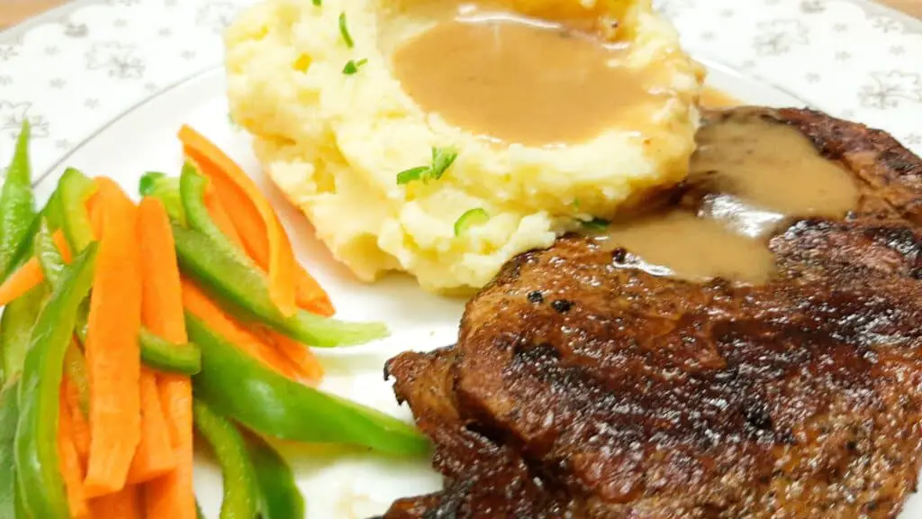 veloute gravy sauce - steak potatoes and vegetables on a plate