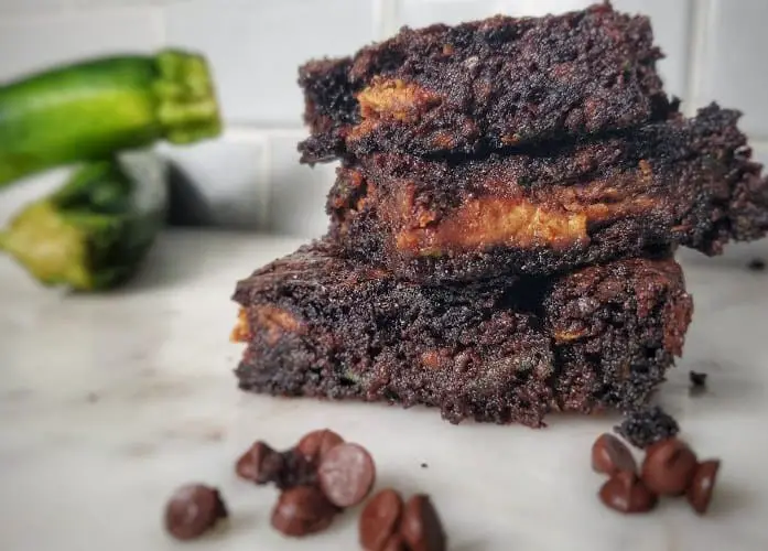 brownies stacked 3 high with chocolate chips and zucchini around them