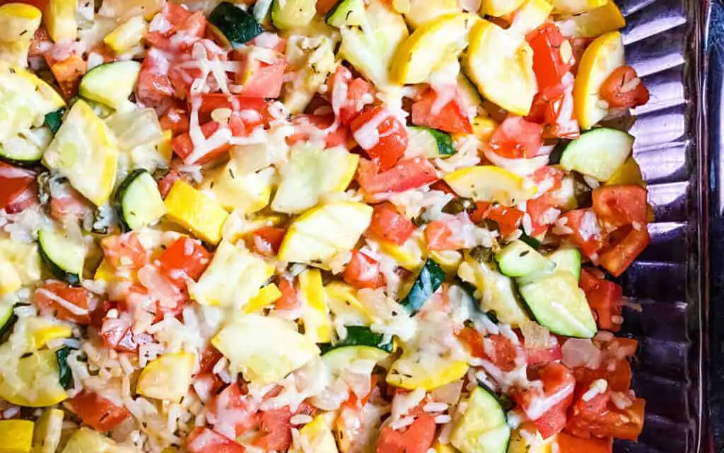 Vegetable casserole of zucchini, squash, tomatoes tossed together and sprinkled with cheese. poolside snacks for summer days