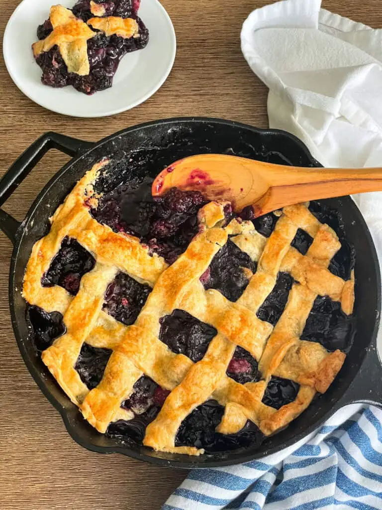 mixed berries in a cast iron skillet with a spoon